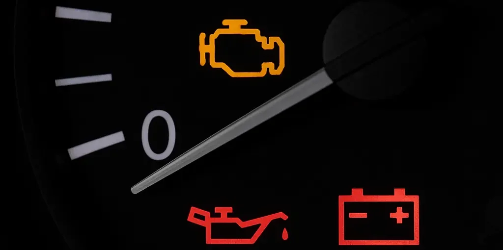 Tableau de bord d’une voiture affichant plusieurs voyants lumineux, dont le voyant moteur, l’huile, la batterie et l’airbag.